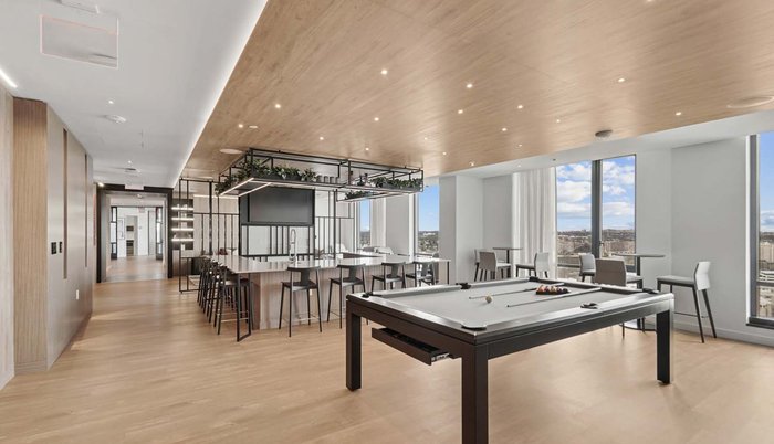 Resident lounge with billiards, bar seating, and skyline views